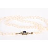 A single row graduated cultured pearl necklace of slight pinkish hue, with fancy yellow metal