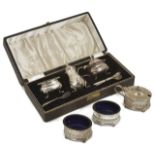 A silver cased cruet set together with an uncased example with pierced acanthus leaf decoration