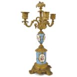A French Sevres style porcelain and ormolu three light candelabra the power blue porcelain painted