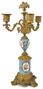 A French Sevres style porcelain and ormolu three light candelabra the power blue porcelain painted