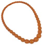 A set of graduated amber coloured beads with screw clasp 20mm to 8mm diameter. 58.5 cm long.