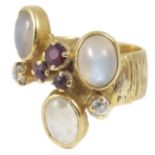 A moonstone, ruby and diamond set ring of modernist design with three central rubies, three oval