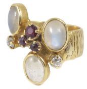 A moonstone, ruby and diamond set ring of modernist design with three central rubies, three oval