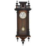 A Victorian walnut Vienna wall clock with white enamel dial and black Roman numerals, within a