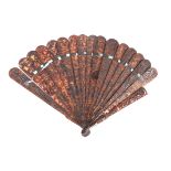 An early 20th century Chinese tortoiseshell fan finely decorated with pierced with scenes of