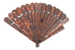 An early 20th century Chinese tortoiseshell fan finely decorated with pierced with scenes of