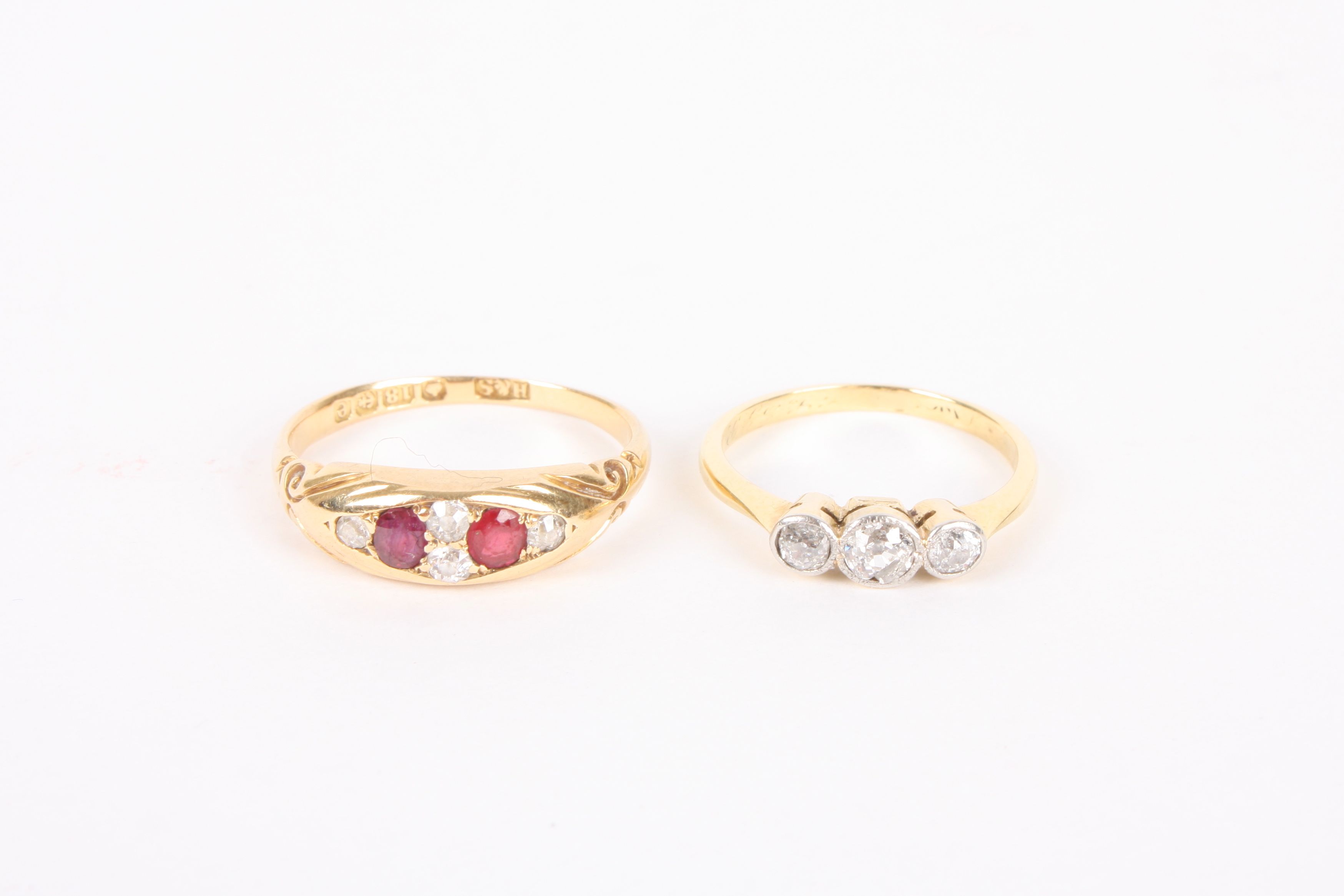 An Edwardian three stone diamond set ring and a Victorian 18ct gold mounted ruby and diamond set