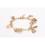 A 9ct gold open curb link charm bracelet with heart padlock fastening, gold charms include a