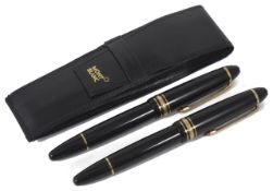 Two Mont Blanc Meisterstuck fountain pens with black resin bodies and gilt hardware, both with 14K