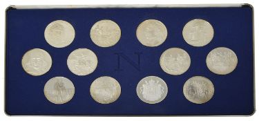 A set of 12 Napoleon Bonapart commemorative silver coins in a fitted case, decorated with crests and
