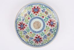 A Chinese famille rose plate decorated with a central roundel, surrounded by enamel flowers, with