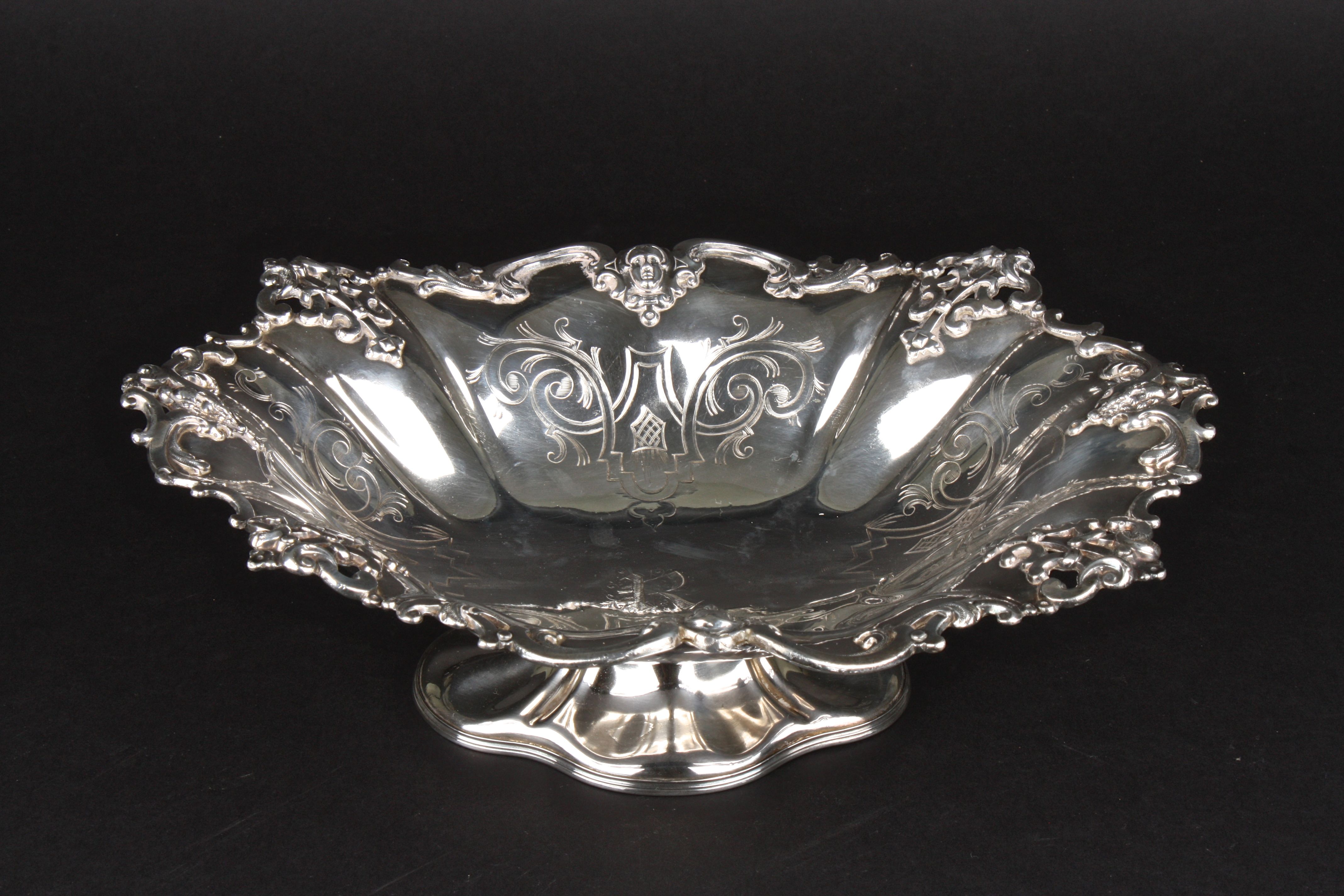 A Victorian silver plated fruit bowl the rim with scrolled and mask decoration and engraved