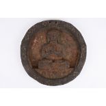 An unusual antique carved wooden plaque carved with a seated Buddha. 22.5 cm diameter.Condition: