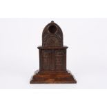A large Victorian carved oak pocket watch stand of architectural form with arched top and pocket