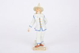 A 20th century Meissen porcelain figure of a clown with pointed hat and wearing a mask. Crossed