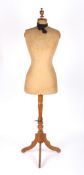 A Victorian dress makers mannequin with fabric covered body and supported on a turned fruitwood