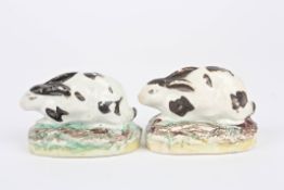 A small pair of Staffordshire pottery seated models of rabbits c. 1830, supported on painted