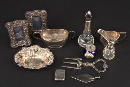 A small group of assorted silver items including two perfume bottles, a silver vesta, two embossed