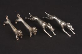 Two pairs of silver plated dog knife rests comprising a pair of greyhounds in racing poses and a