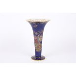A Carlton Ware Bleu Royale trumpet vase decorated with a vase of enamel flowers with rich gilt