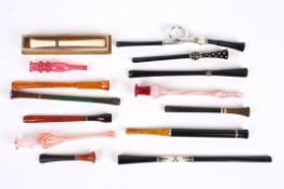 A collection of eleven assorted 1920s cigarette holders of various shapes and designs, some