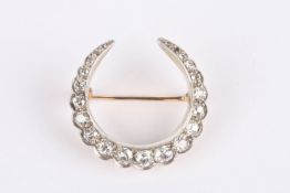 A late Victorian diamond crescent brooch set with old cut diamonds graduating in size and tapering
