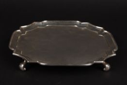 A George V rectangular silver salver hallmarked London 1932, with shaped rim and canted corners,