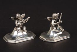 A pair of Stirling silver menu holders formed as cherubs playing musical instruments. Condition: