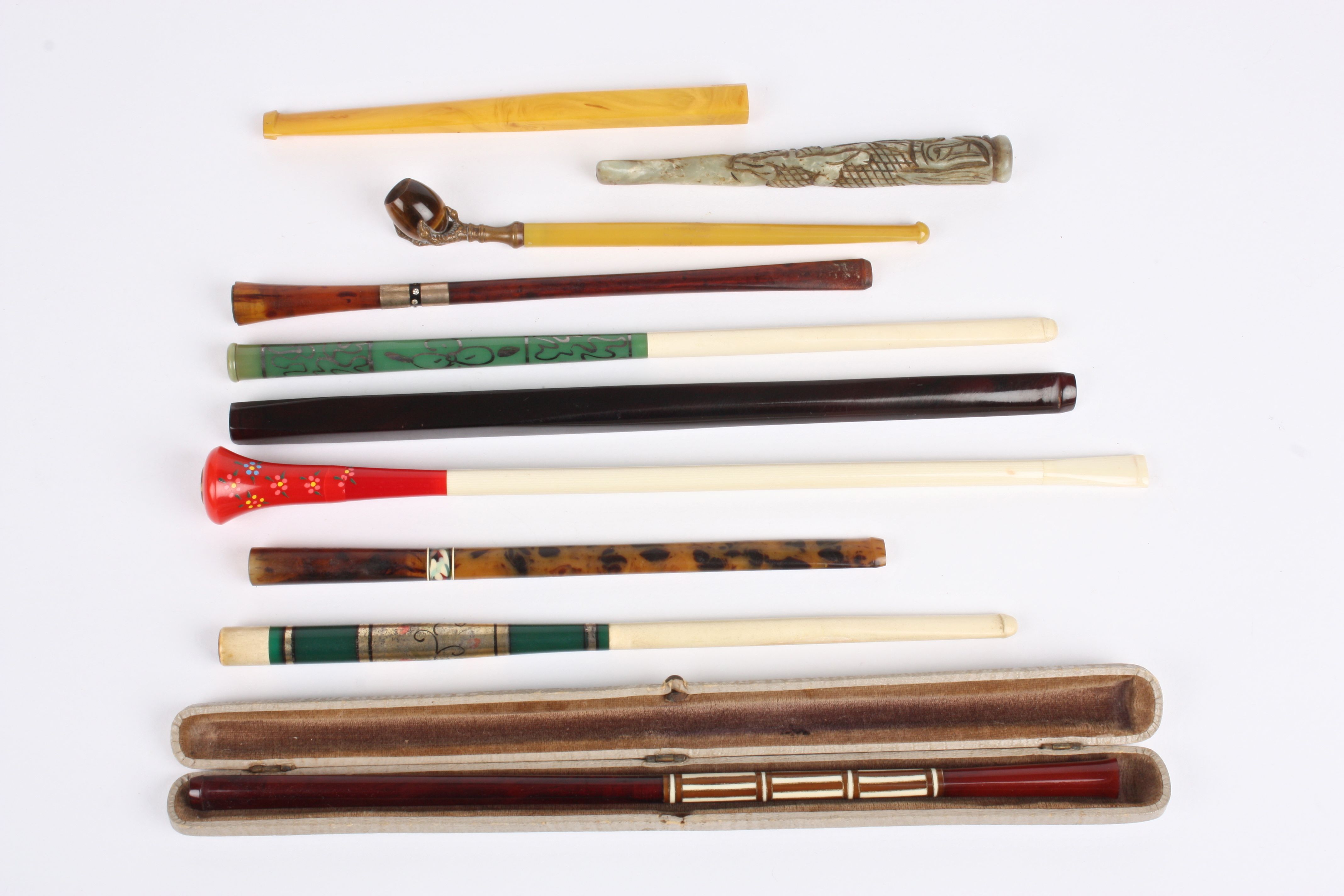 A collection of ten 1920s and 30s cigarette holders of various shapes and designs, one with tigers