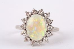 An oval opal and diamond cluster ring the central opal with good colour mounted within a single