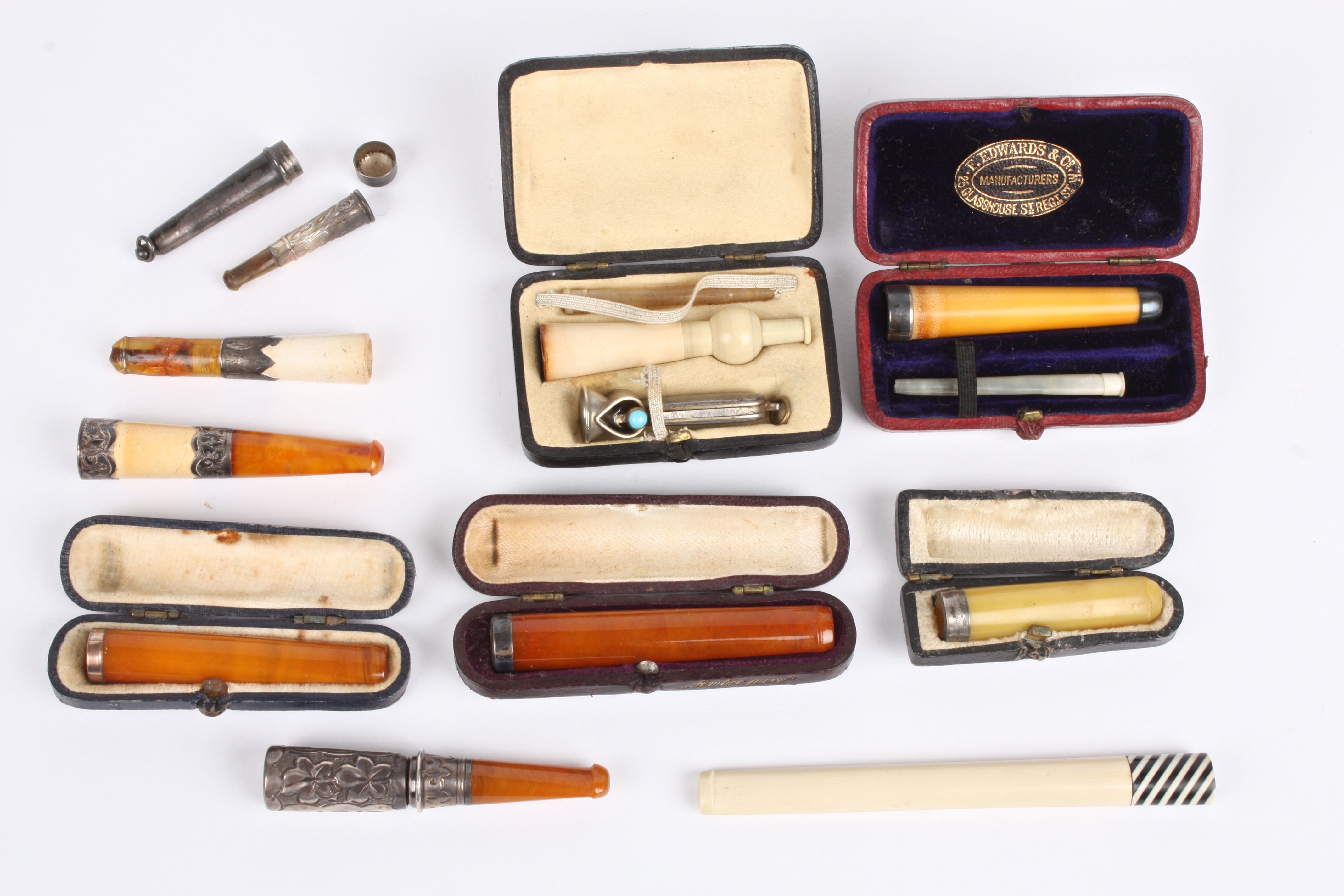 A collection of ten assorted cigarette holders some with silver mounts, and others in fitted