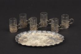 A set of silver Continental silver and glass spirit cups and a tray the tray embossed with