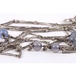 A 1920s silver and moonstone long necklace set with six moonstone coloured beads on a wire twist