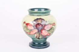 A small Moorcroft flower vase with tubelined decoration on a green ground. With Moorcroft label to