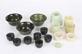 A collection of assorted modern carved Chinese spinach hardstone bowls and cups of various sizes and