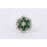 A 9ct white gold, emerald and diamond cluster ring the central diamond weighing 6pts, surrounded