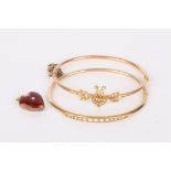 Two delicate Edwardian pearl set bangles one hinged and with central lyre motif with foliate
