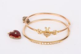 Two delicate Edwardian pearl set bangles one hinged and with central lyre motif with foliate