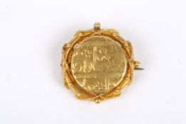 An antique Islamic gold coin mounted as a brooch the coin with script to front and reverse,