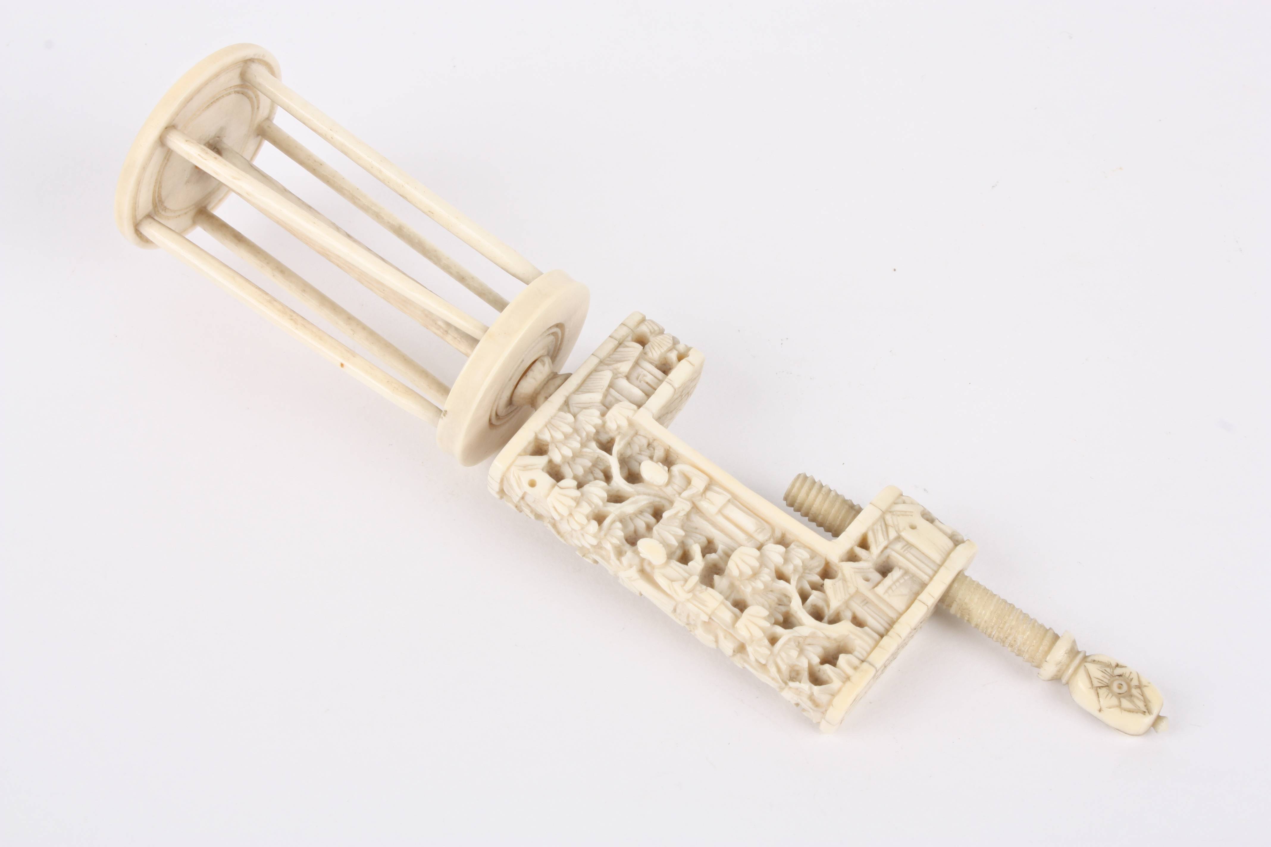 A late 19th century Chinese canton ivory bobbin clamp carved with figures, buildings and foliage.