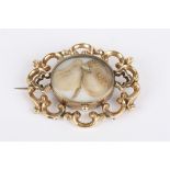 A Victorian scroll memorial brooch of open pierced design with central hair and pearl detail