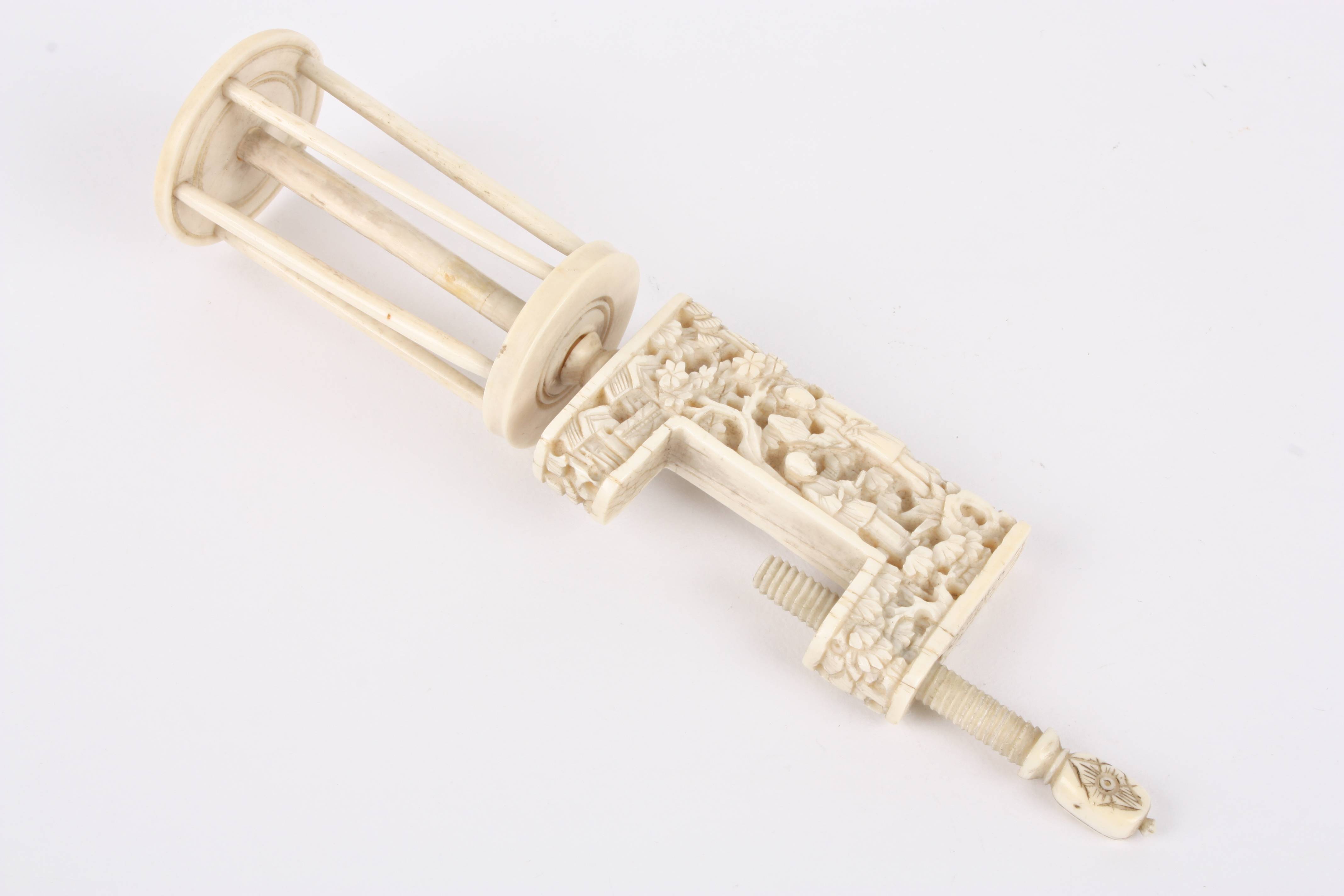 A late 19th century Chinese canton ivory bobbin clamp carved with figures, buildings and foliage. - Image 2 of 3