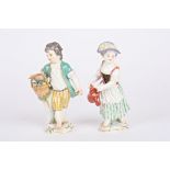 A pair of 20th century Meissen porcelain figures of a gardening boy and girl the boy with a basket