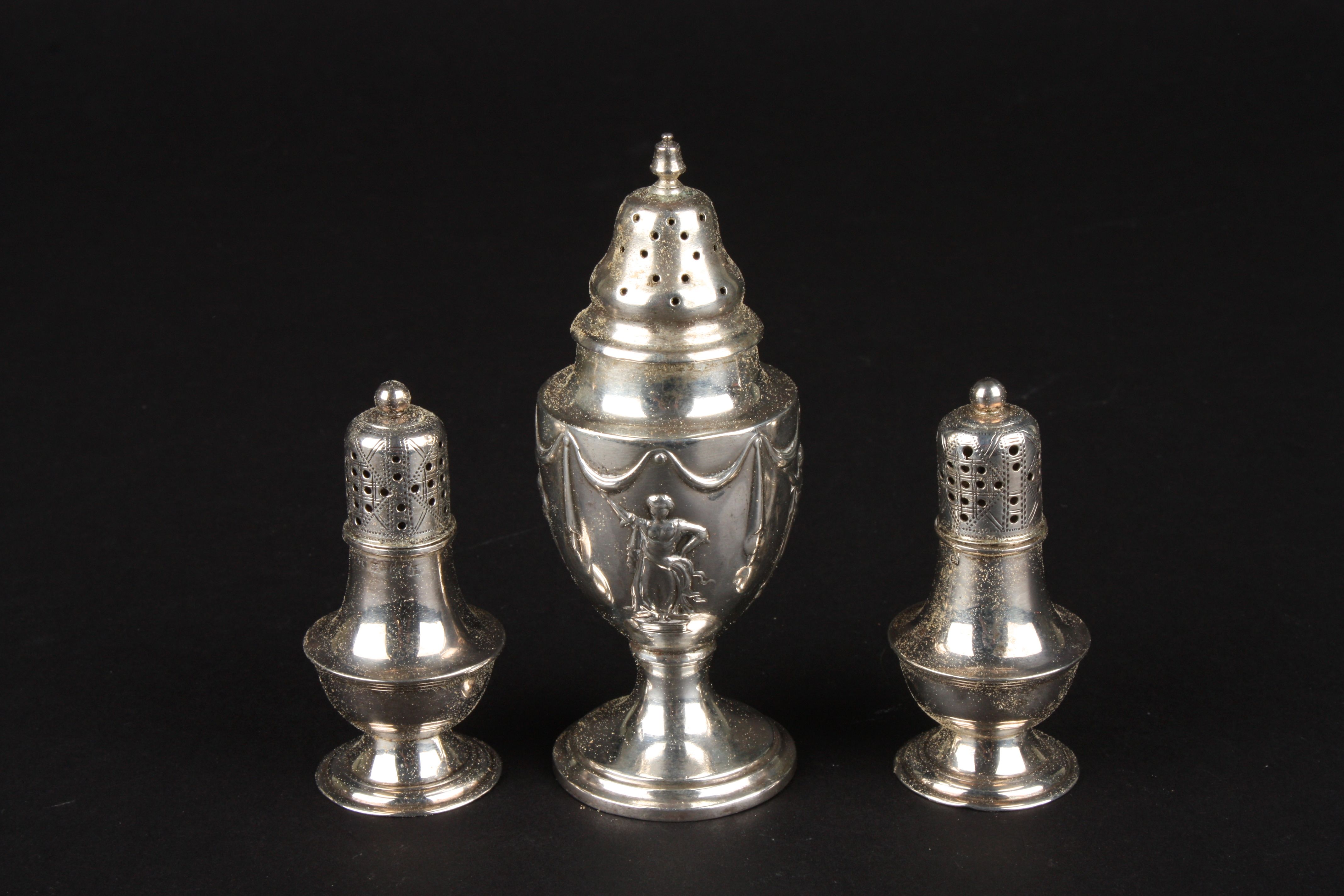 A baluster shaped silver pepperette with repoussé Roman figure decoration, together with a smaller