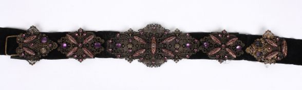 An Edwardian ladies filigree and fancy glass dress belt the components stitched to a velvet belt