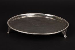 A George III silver circular salver hallmarked London 1786, with beaded rim and engraved heraldic