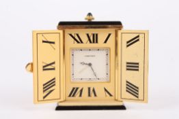 A Must de Cartier gilt metal travel clock with engraved sunburst decoration, the two doors opening