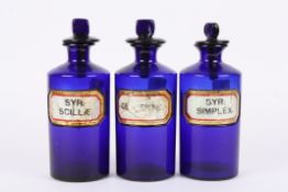 A set of three 19th century Bristol blue glass apothecary jars with inset glass labels 'SYR: