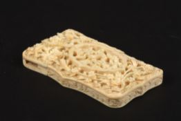 A Chinese Canton carved ivory calling case, c.1900 of shaped form, one side domed and carved in