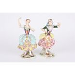 A pair of porcelain figures of dancing girls 'Asselin' and 'Pitrot', both wearing floral dresses and